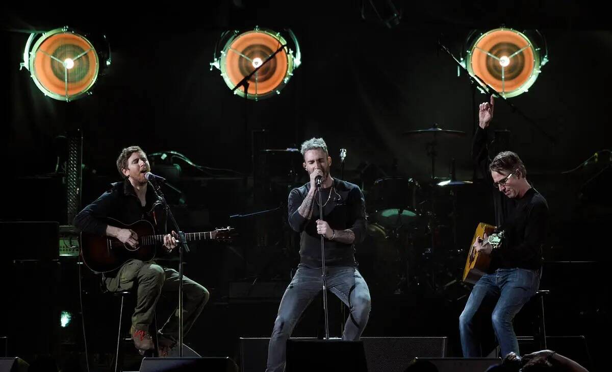 Adam Levine, en el centro, y Jesse Carmichael, a la izquierda, de la banda Maroon 5 se presenta ...