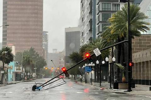 Un poste de semáforo derribado por los vientos del huracán Ian, yace en Orange Avenue en el c ...