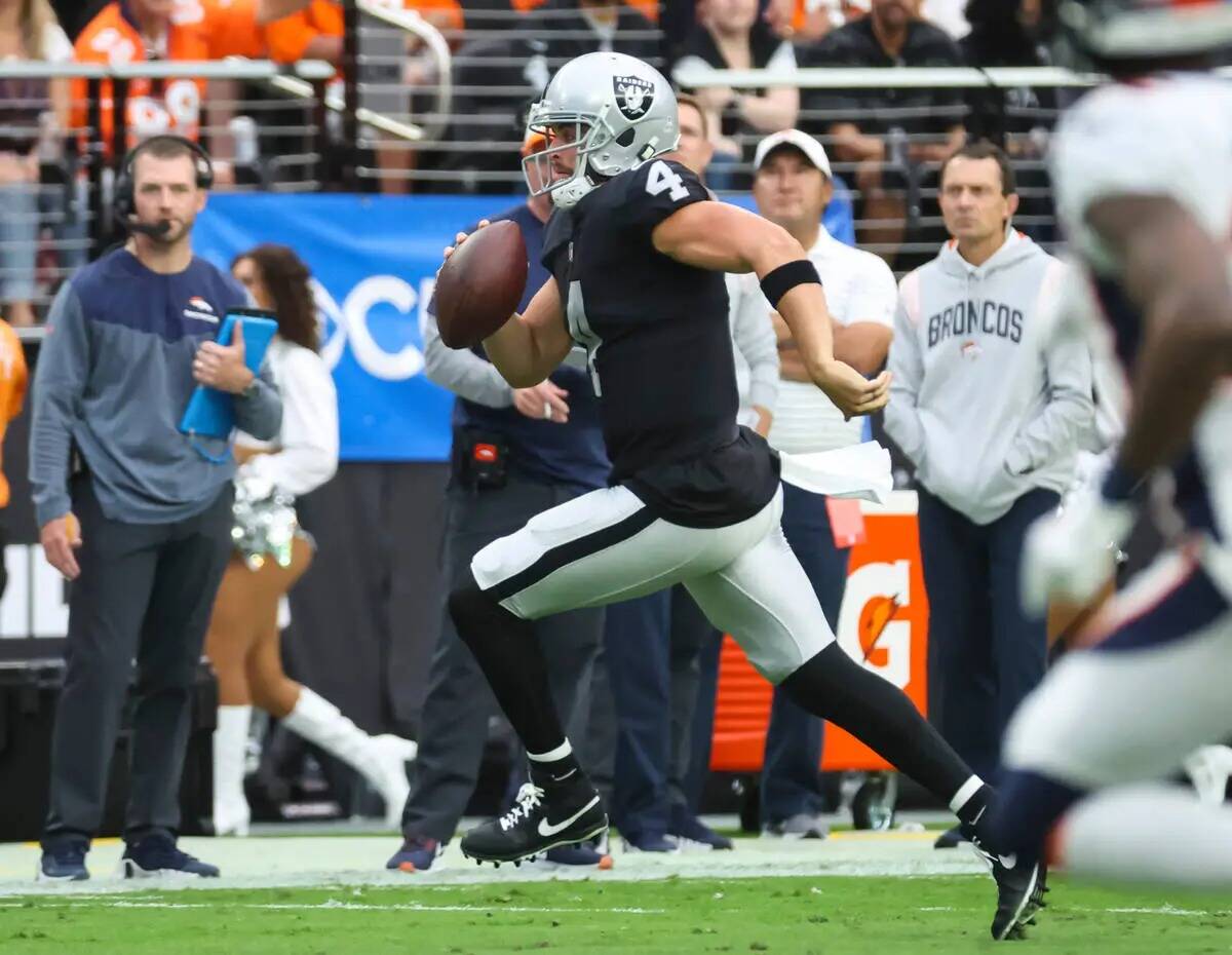 El quarterback de los Raiders Derek Carr (4) corre con el balón contra los Denver Broncos dura ...