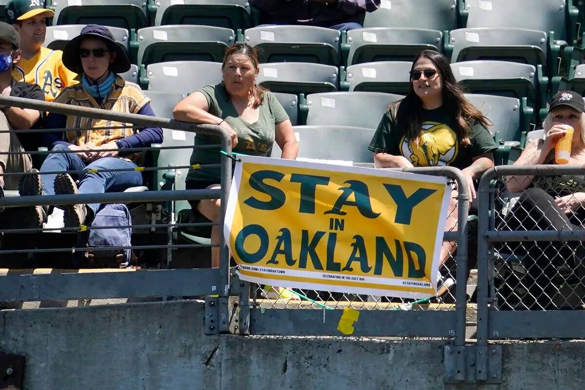 Los aficionados se sientan detrás de un cartel que dice "Stay in Oakland" durante la primera e ...