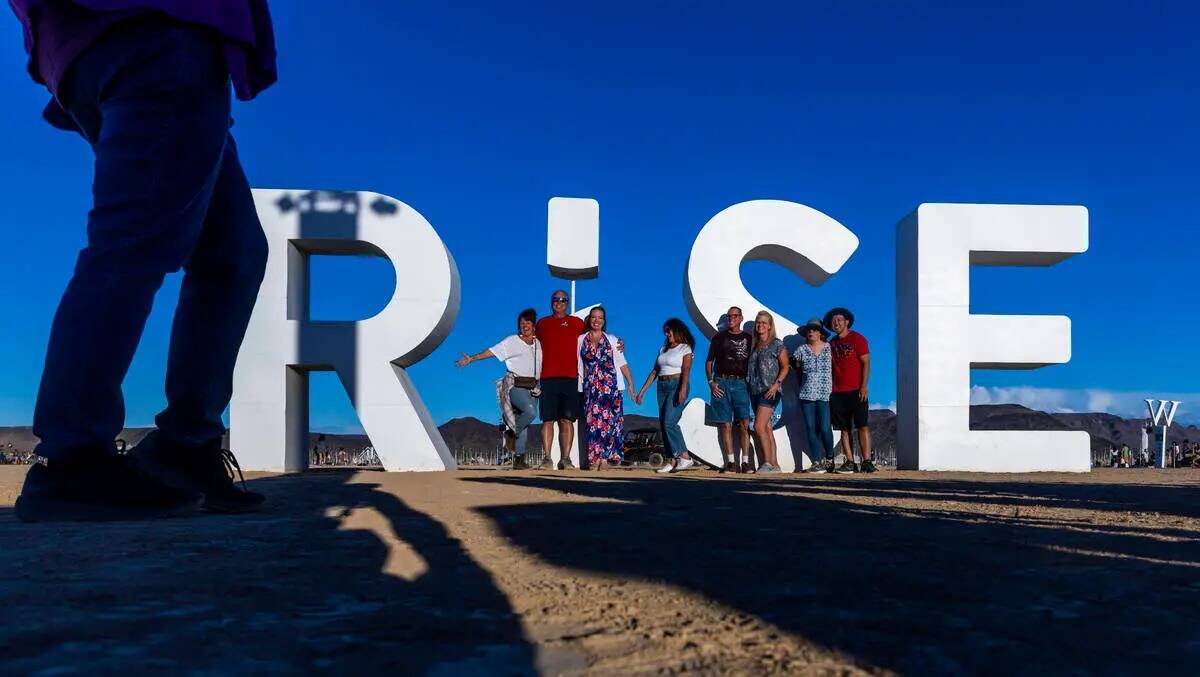 Los amigos se reúnen en las letras gigantes dentro de la entrada durante RiSE Lantern Fest en ...