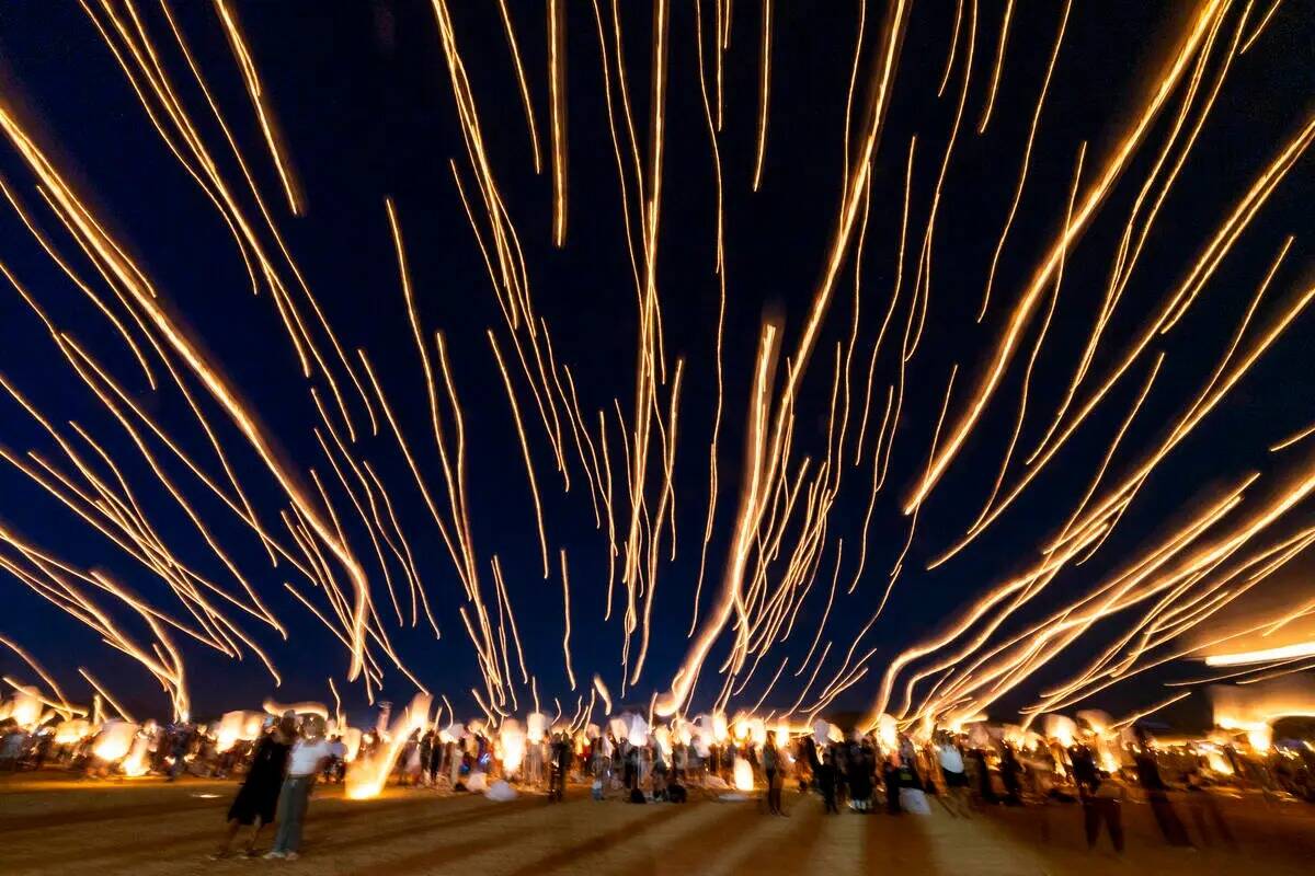 La gente suelta linternas en grupo durante el RiSE Lantern Fest en el Jean Dry Lake Bed el vier ...