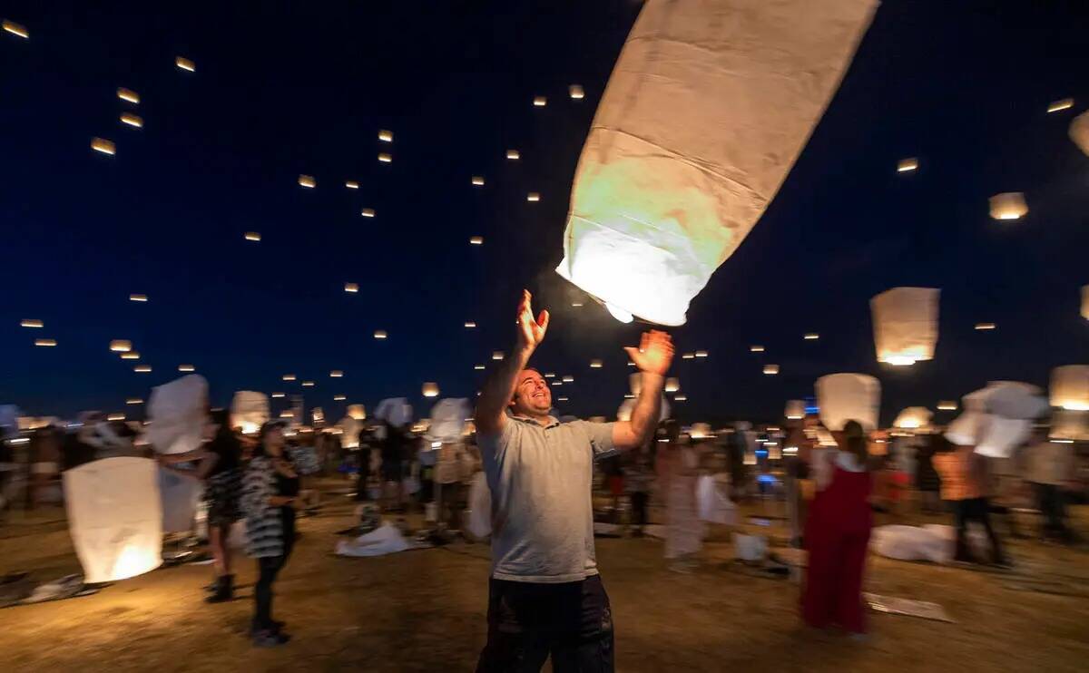 Un participante suelta su linterna con el grupo durante RiSE Lantern Fest en Jean Dry Lake Bed ...