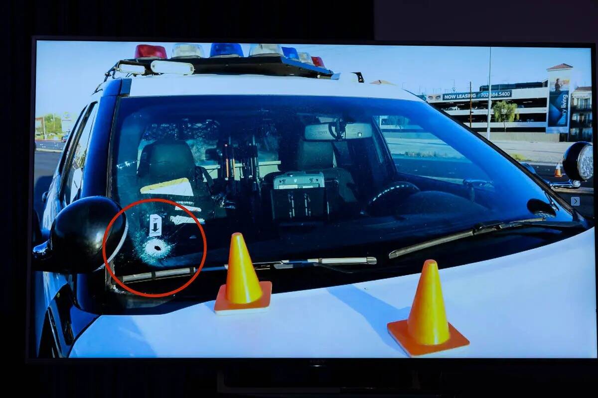 Un agujero de bala se ve en la ventana de un vehículo de la policía después de un tiroteo co ...