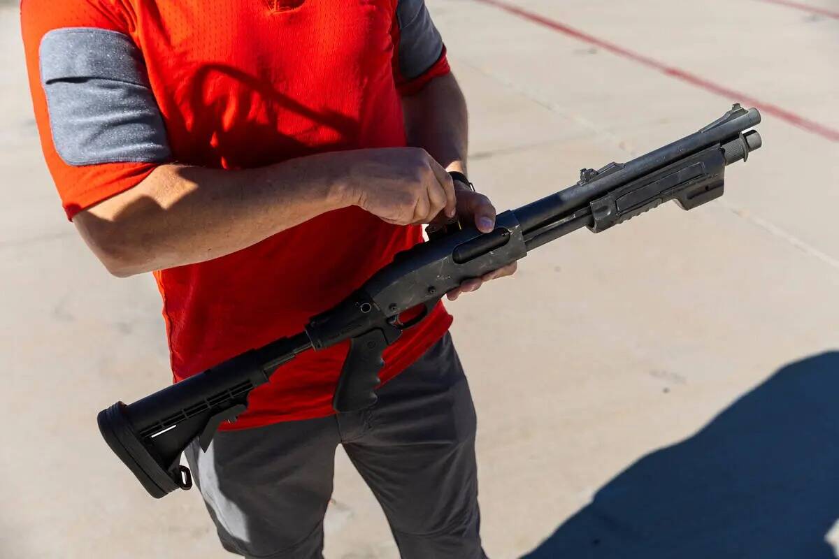 Un instructor/agente especial del FBI carga una escopeta Remington 870 durante un día de campo ...