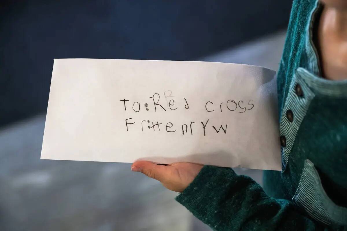 Henry Williams, de seis años, sostiene el sobre de 800 dólares que ganó para la Cruz Roja Am ...