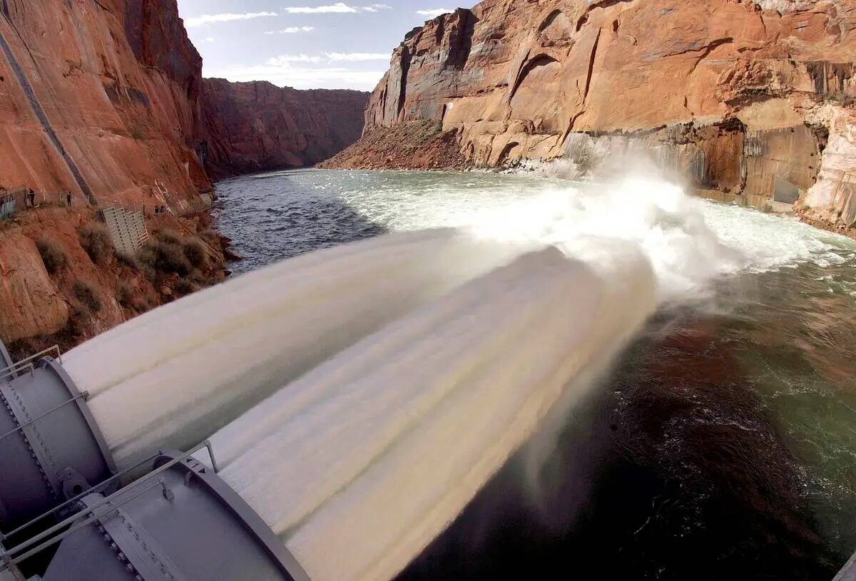 ARCHIVO*** El agua fluye desde los tubos de chorro número uno y dos en la Presa de Glen Canyon ...