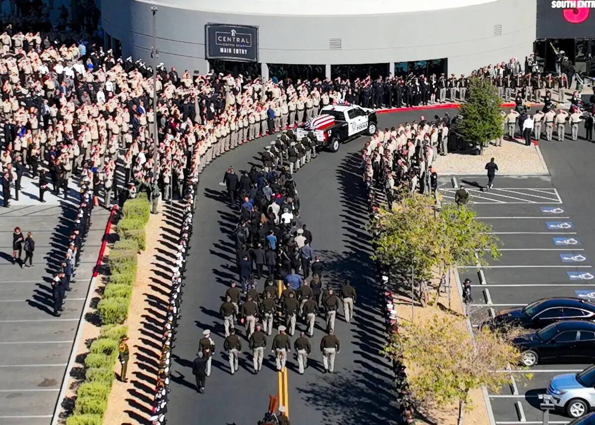 Agentes de policía de Las Vegas saludan mientras el vehículo fúnebre que transporta el fére ...