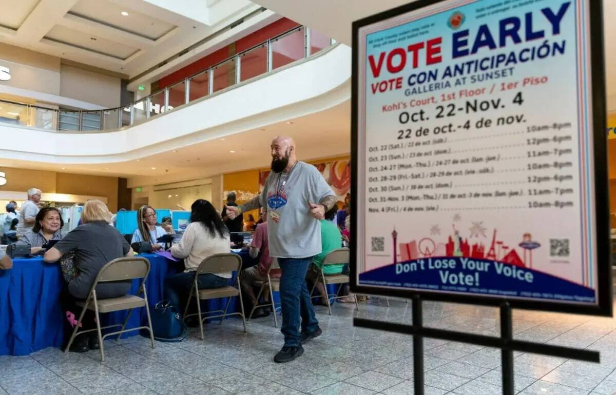 El trabajador electoral Phil Hallond dirige a la gente en el centro electoral dentro del centro ...