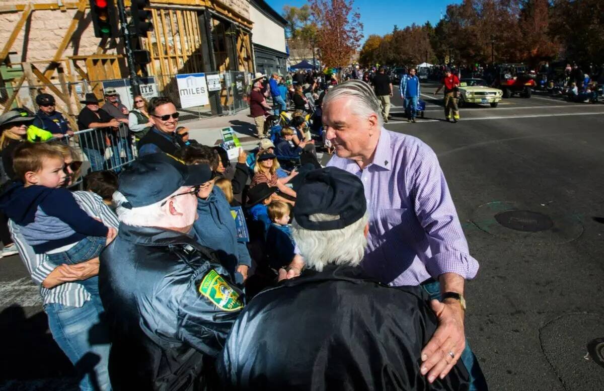 El gobernador Steve Sisolak saluda a Dan Dulong, a la izquierda, y a Fred Webb, voluntarios de ...