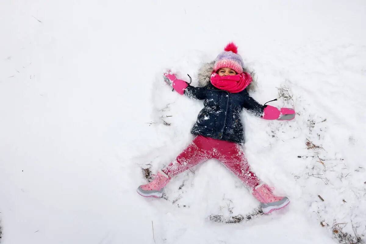 Ángel Frías-Irizarry, de tres años, de Las Vegas hace un ángel de nieve en la nieve recién ...