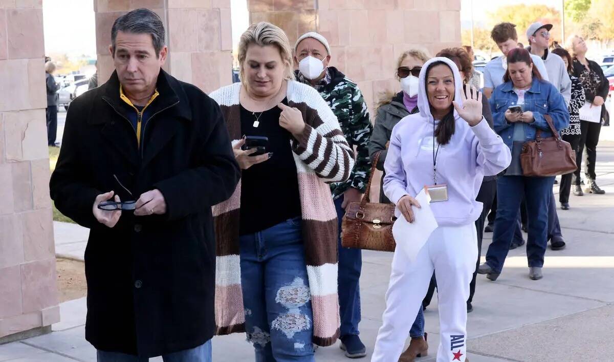 Los votantes, incluyendo a Gainer Seliminska de Las Vegas, saludando, hacen fila para emitir su ...