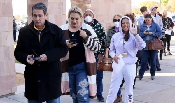 Los votantes, incluyendo a Gainer Seliminska de Las Vegas, saludando, hacen fila para emitir su ...