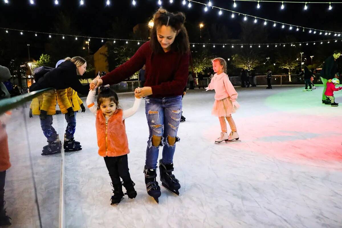 Mia Meija, de 11 años, guía a su hermana pequeña Gabby Barreto, de dos años, sobre el hielo ...