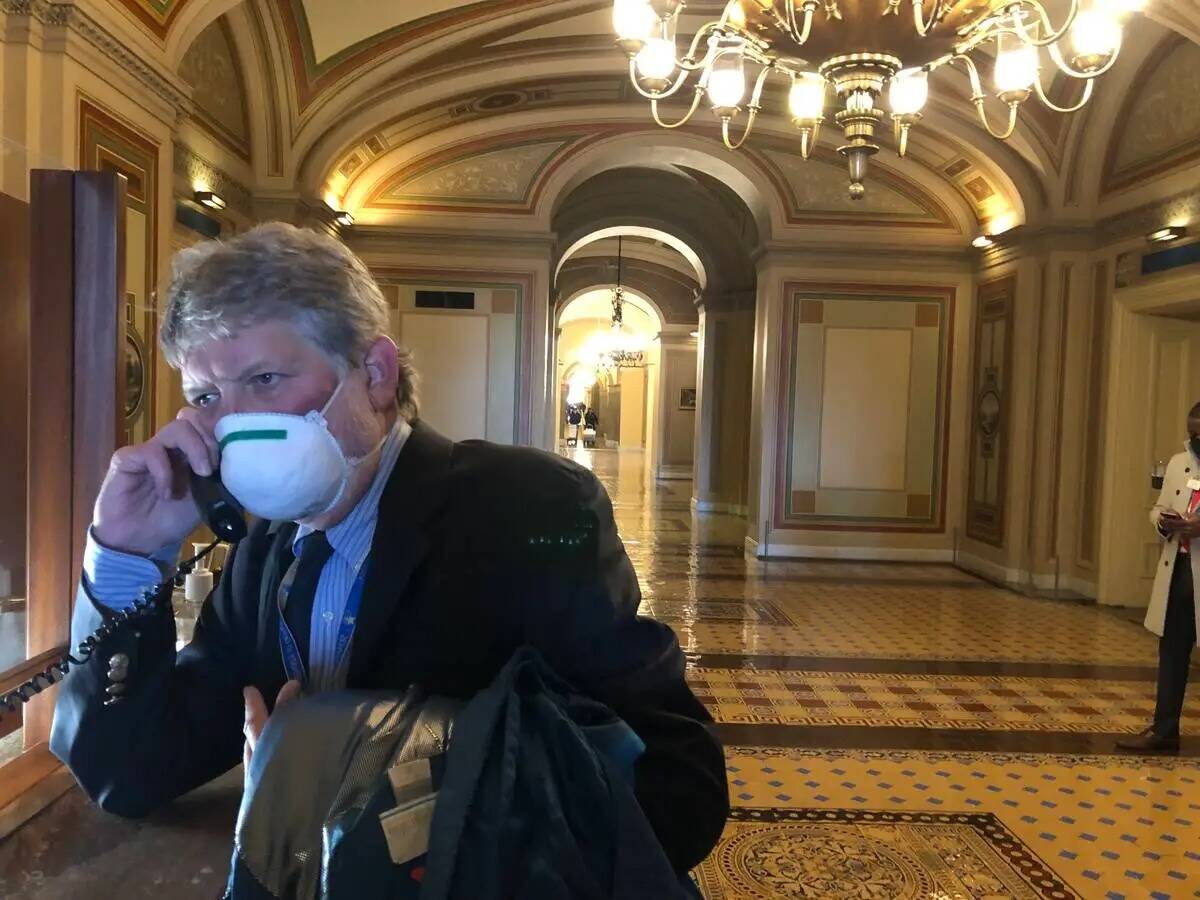 Gary Martin hablando por teléfono con un contacto en el vestíbulo del edificio del Capitolio ...