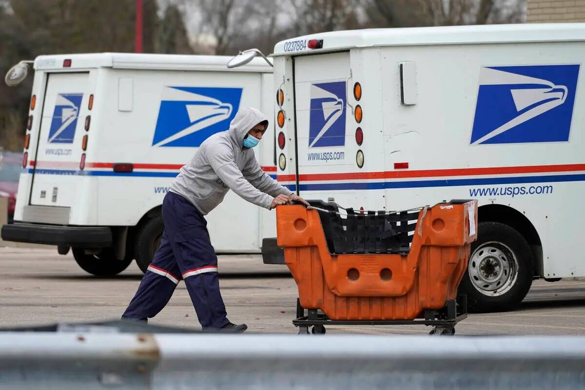 Un empleado del Servicio Postal de Estados Unidos trabaja fuera de una oficina de correos en Wh ...