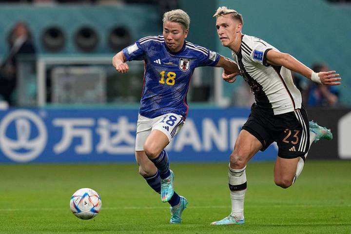 Takuma Asano de Japón, a la izquierda, lucha por el balón con Nico Schlotterbeck de Alemania, ...