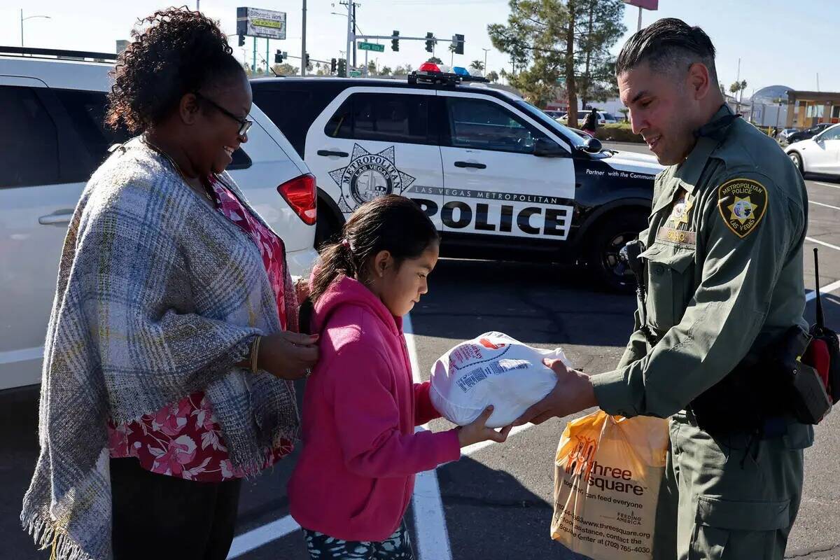 El agente de policía de Las Vegas Alfredo Calata, entrega comida de Thanksgiving a Maria Archi ...