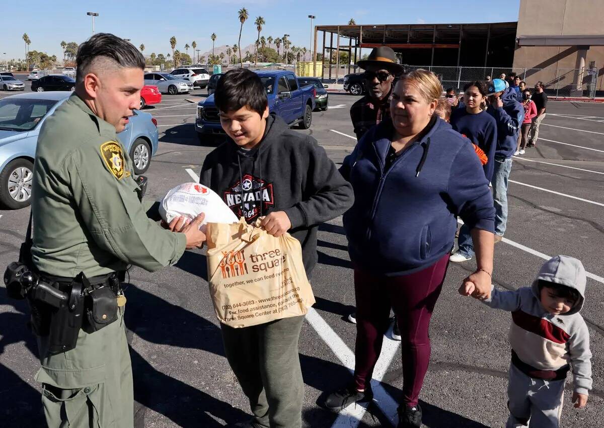 El agente de policía de Las Vegas, Alfredo Calata, entrega comidas de Thanksgiving a familias ...