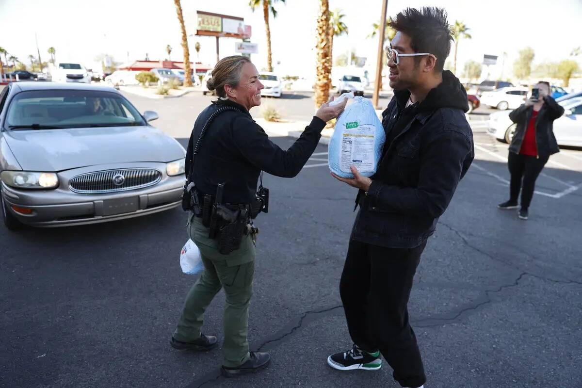 La agente de policía Deborah Rinkovsky, a la izquierda, le regala un pavo a Jake Wang de Las V ...