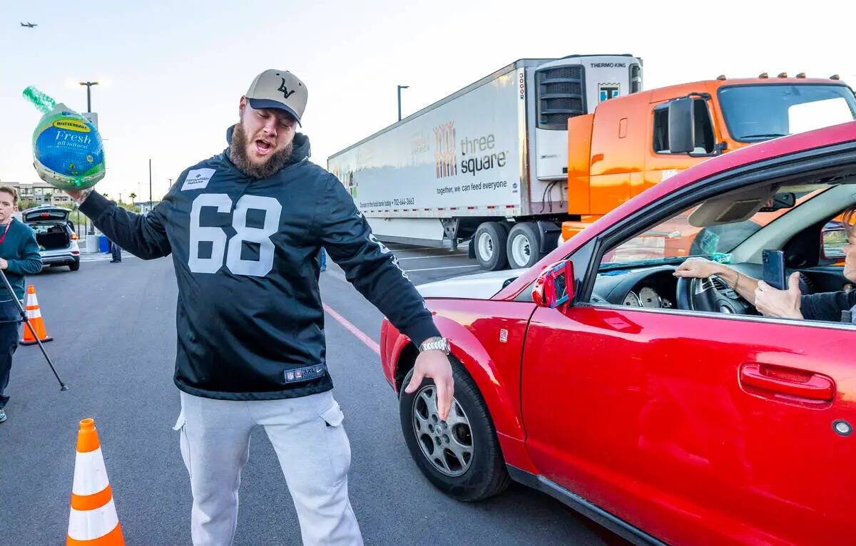 El centro de los Raiders Andre James (68) finge hacer una anotación con un pavo mientras se un ...