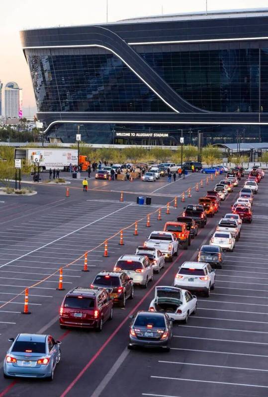 Los autos se abren paso alrededor del Allegiant Stadium mientras jugadores actuales y anteriore ...