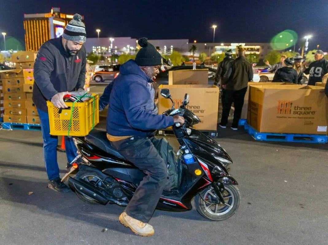 El ex TE de los Raiders Teyo Johnson (82) asegura una carga de alimentos entregada a Terrence H ...