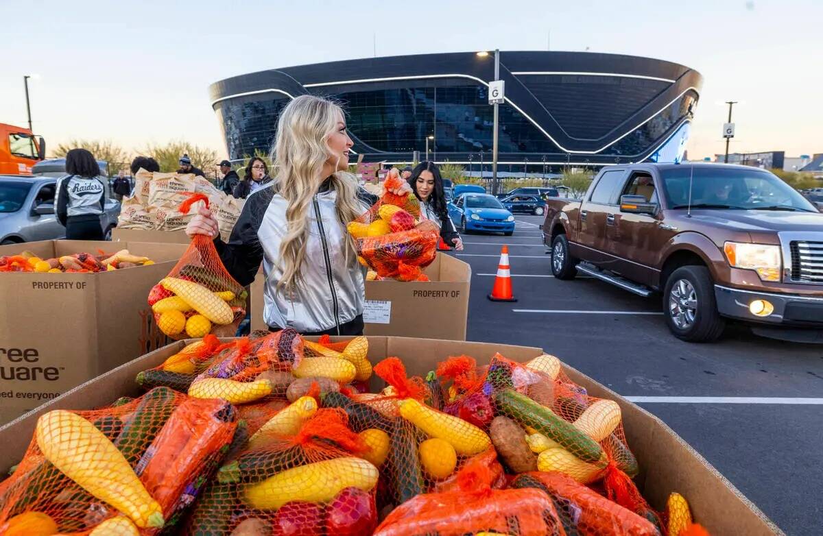 Las Raiderettes Melody y Kylie entregan bolsas de fruta y verdura junto a jugadores actuales y ...