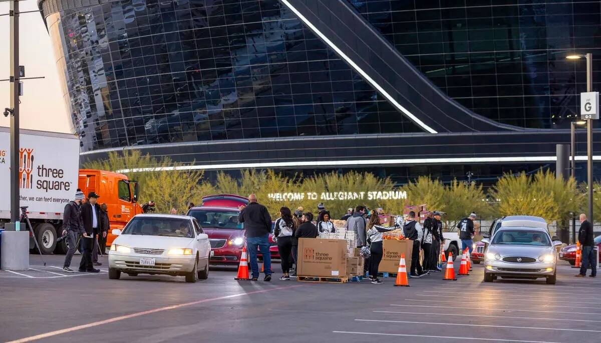 Los autos se abren paso alrededor de Allegiant Stadium mientras jugadores actuales y anteriores ...