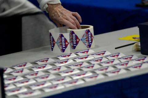 Un trabajador electoral coloca calcomanías de "Yo voté" en un centro electoral el martes 8 de ...