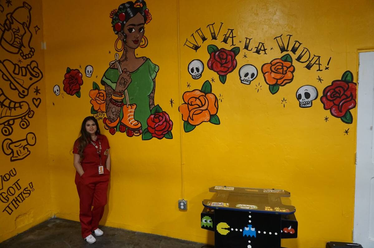 Amanda Quintanilla, propietaria de Fresa's Skate Shop, posa junto a un mural realizado por la a ...
