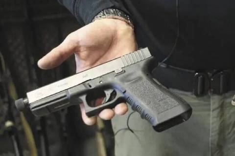 Matt Supnick sostiene una pistola semiautomática Glock en Las Vegas el miércoles 16 de enero ...