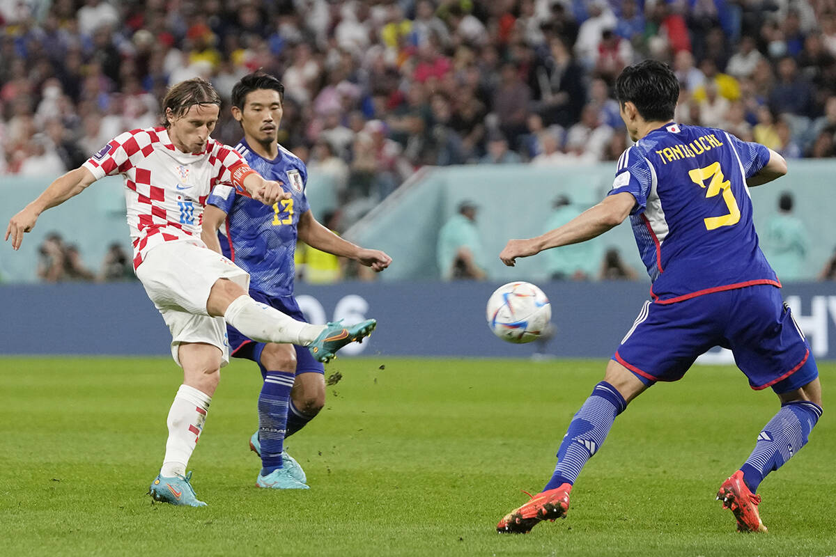 El croata Luka Modric, izquierda, patea el balón por delante del japonés Hidemasa Morita, cen ...