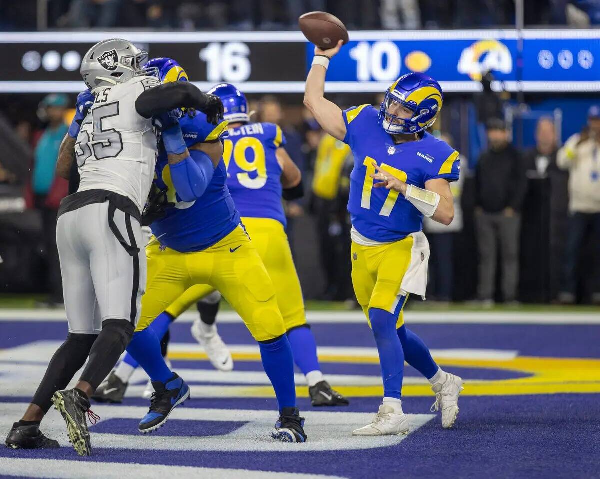 El quarterback de los Angeles Rams Baker Mayfield (17) lanza mientas mientras el defensive end ...