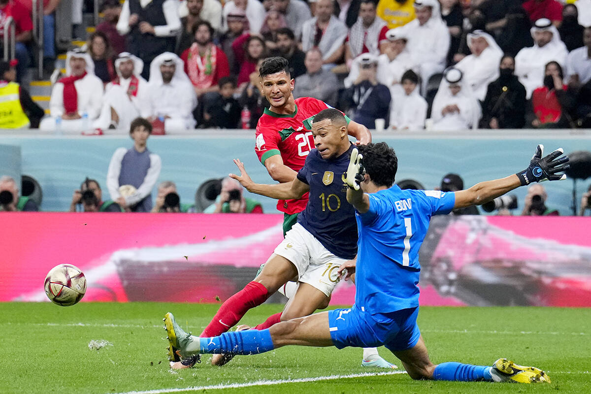 El portero marroquí Yassine Bounou corta y ataca al francés Kylian Mbappe durante el partido ...