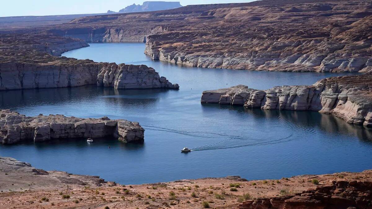 ARCHIVO - Un bote navega por el Lago Powell cerca de Page, Arizona, el 31 de julio de 2021. Los ...
