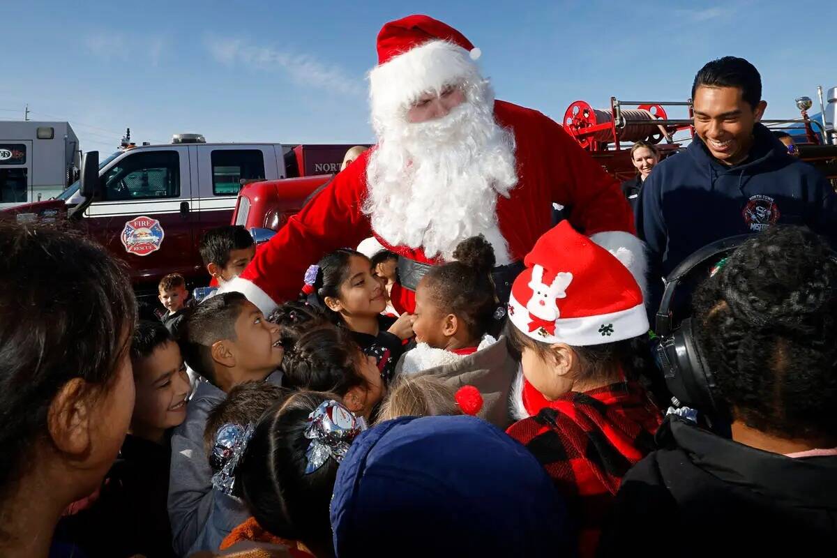 Santa Claus saluda a los alumnos tras llegar en helicóptero a la Fay Herron Elementary School, ...