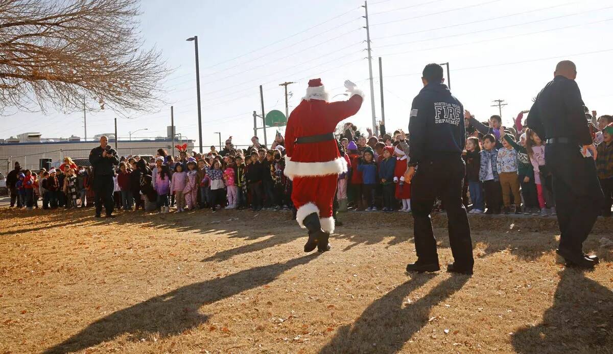 Santa Claus saluda a los alumnos tras llegar en helicóptero a la Fay Herron Elementary School, ...