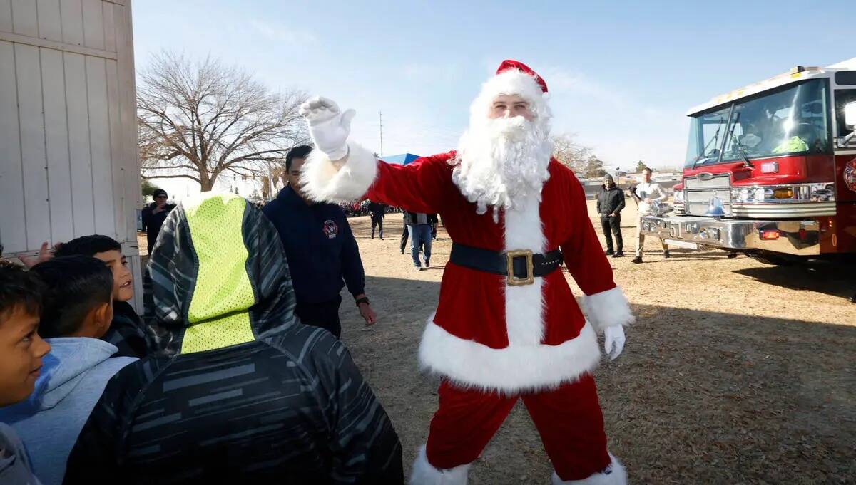 Santa Claus saluda a los alumnos tras llegar en helicóptero a la Fay Herron Elementary School, ...