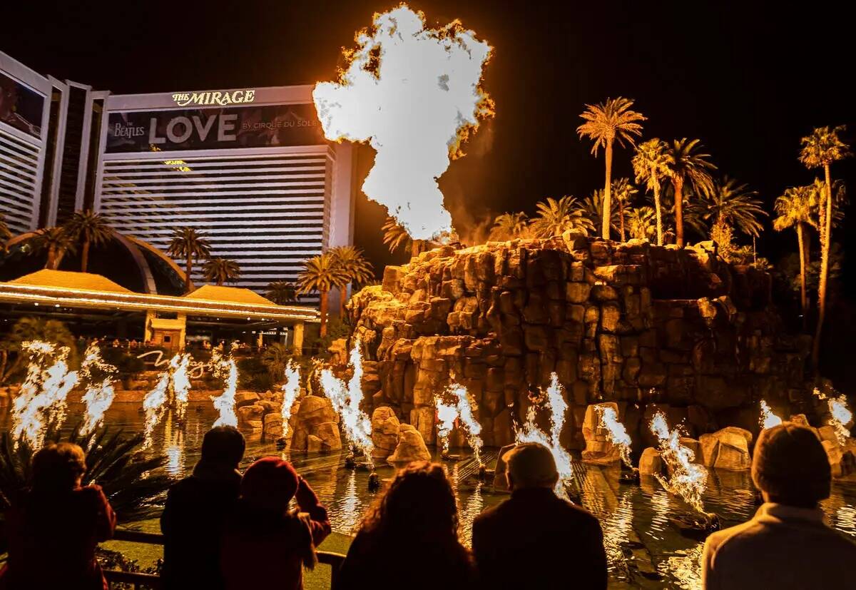 La gente observa el espectáculo del volcán en el Strip de Las Vegas, en el exterior de The Mi ...