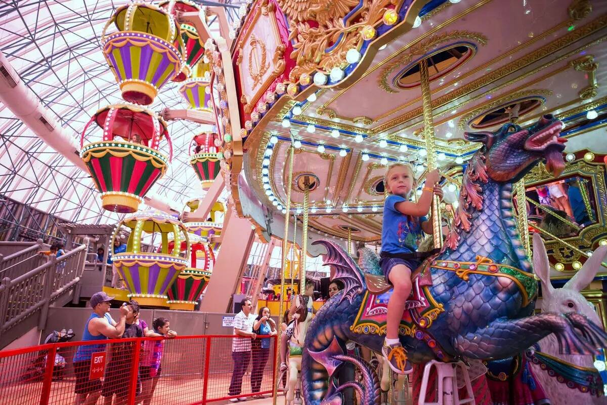 Niños montan en el carrusel en el parque temático Adventuredome dentro de Circus Circus el vi ...