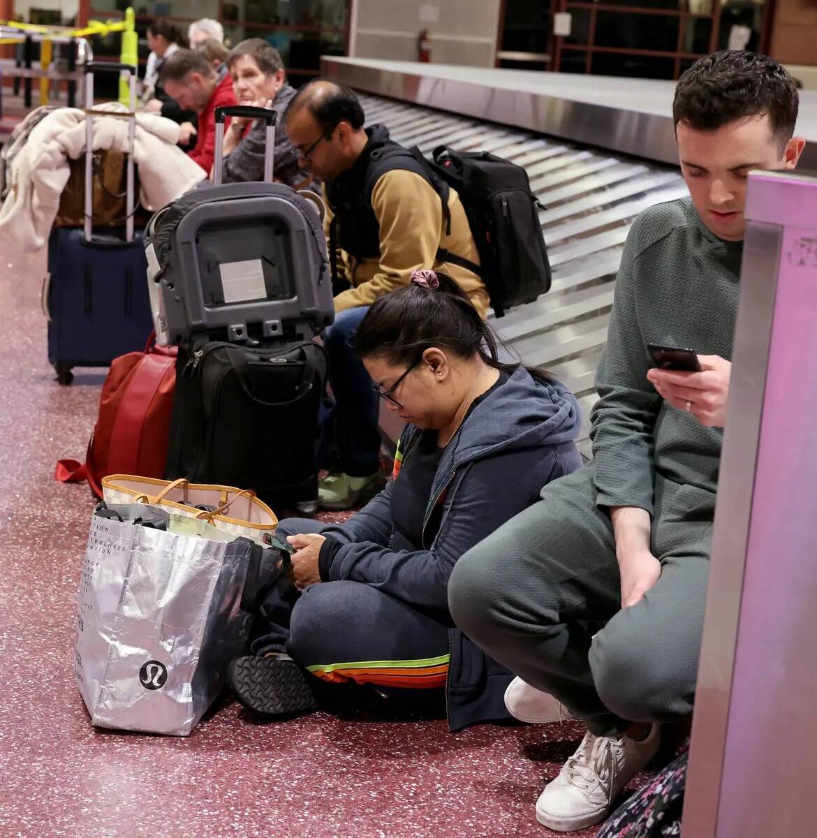 Viajeros esperan para recuperar su equipaje de vuelos cancelados y retrasados en el reclamo de ...