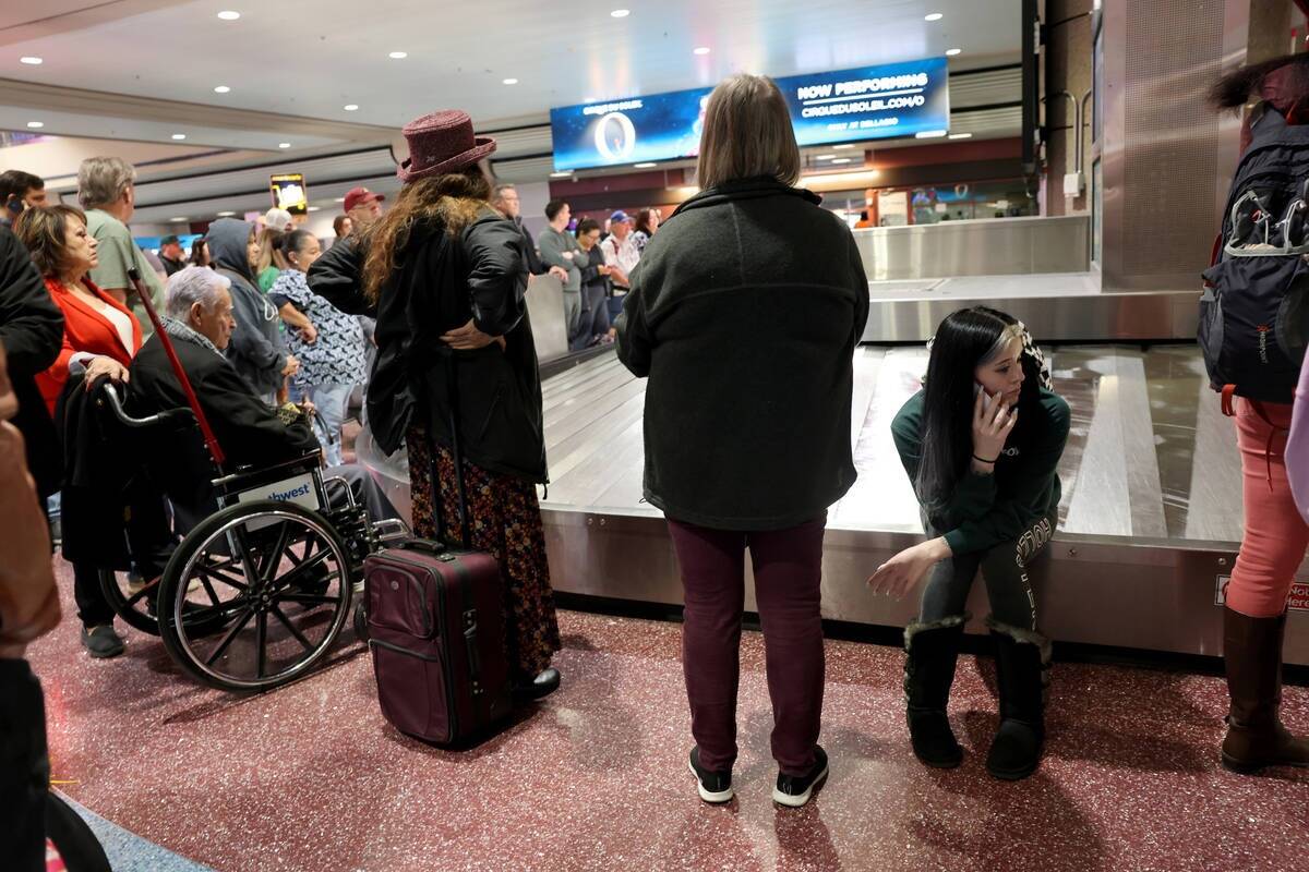 Viajeros, entre ellos Raylene O'Connor de Tonto Basin, Arizona, sentada, esperan para recuperar ...