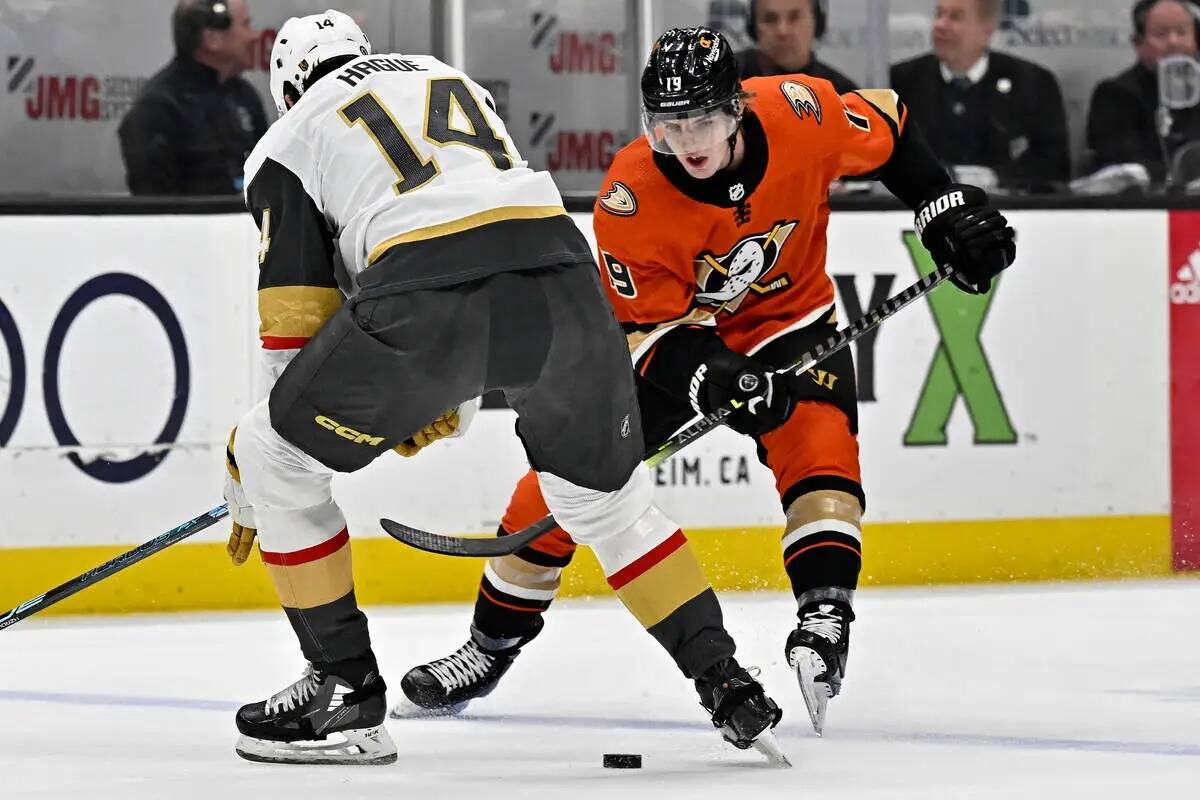 El ala derecha de los Anaheim Ducks, Troy Terry, a la derecha, pasa el puck entre los patines d ...