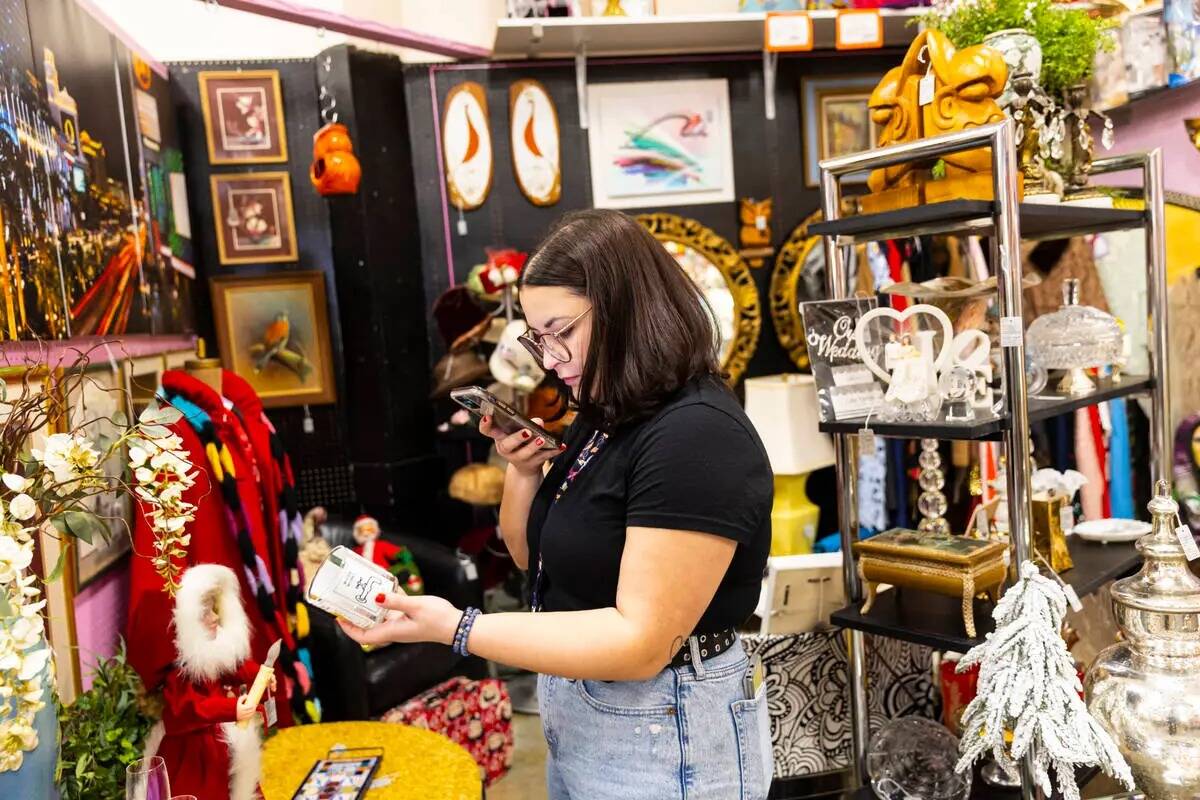 Rebecca Robledo, gerente de redes sociales en Charleston Antique Mall, graba un video de una ta ...