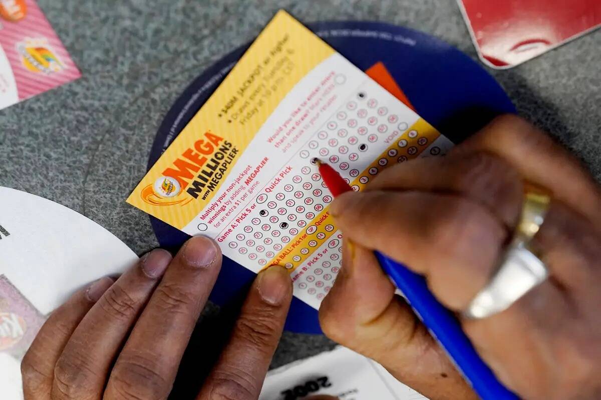 Un cliente llena un billete de lotería Mega Millions en una tienda de Northbrook, Illinois, el ...