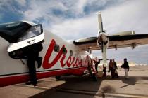 Un piloto de Vision Airlines sube a la cabina de uno de los aviones turbohélice Dornier 228 de ...