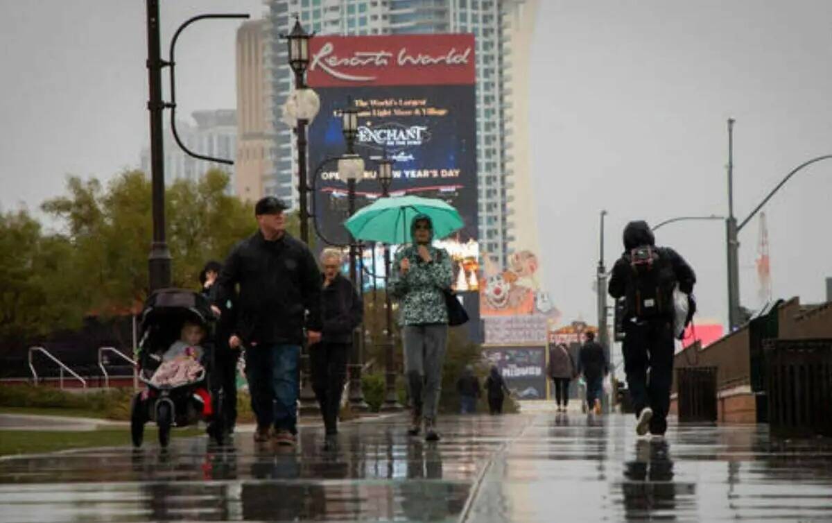 La gente camina bajo la lluvia en el Strip el domingo 11 de diciembre de 2022 en Las Vegas. (Am ...
