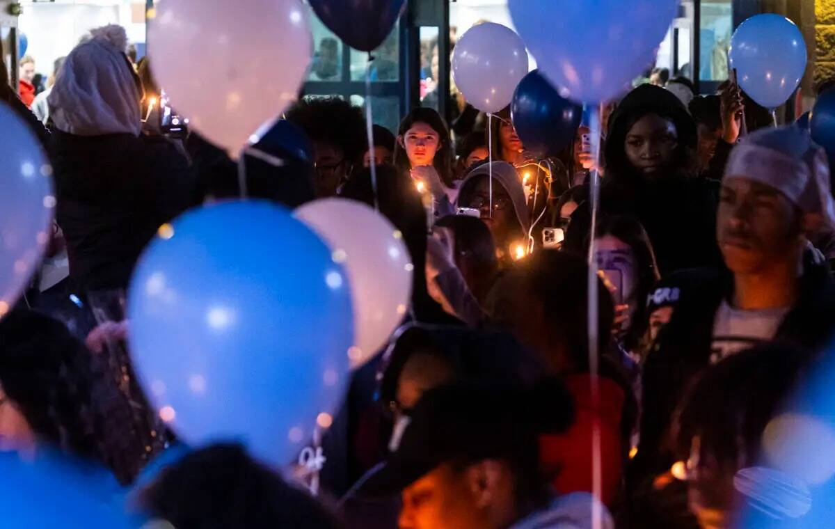 Amigos y familiares de Ashari Hughes, de 16 años, sostienen velas durante una celebración de ...