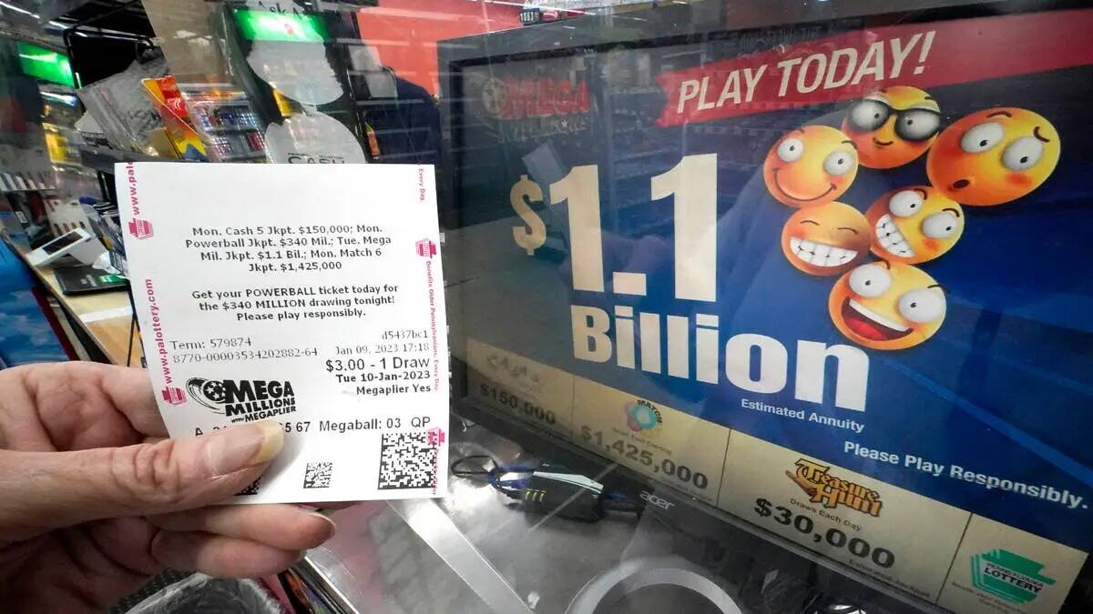 Una clienta de Mega Millions muestra su boleto para el premio mayor estimado de 1,100 millones ...